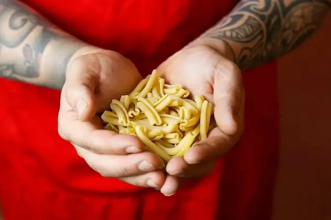 raw-pasta-hands-apron-casarecce-pasta