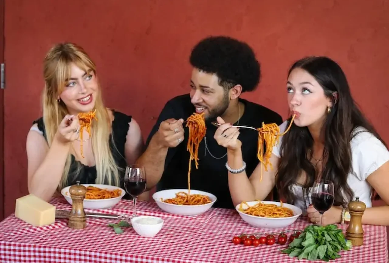Young people enjoying eating pasta mobile